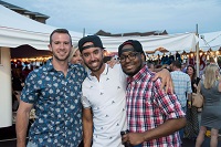 Three alumni pose together at Porch Party