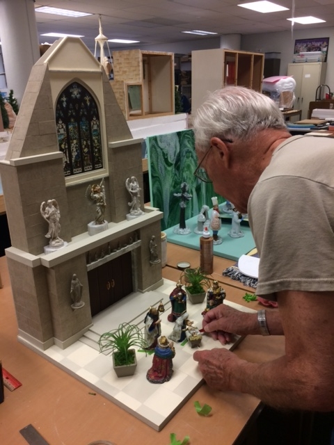 Harry Mushenheim working on the cathedral in the Marian Library's crèche workshop located in Fitz Hall