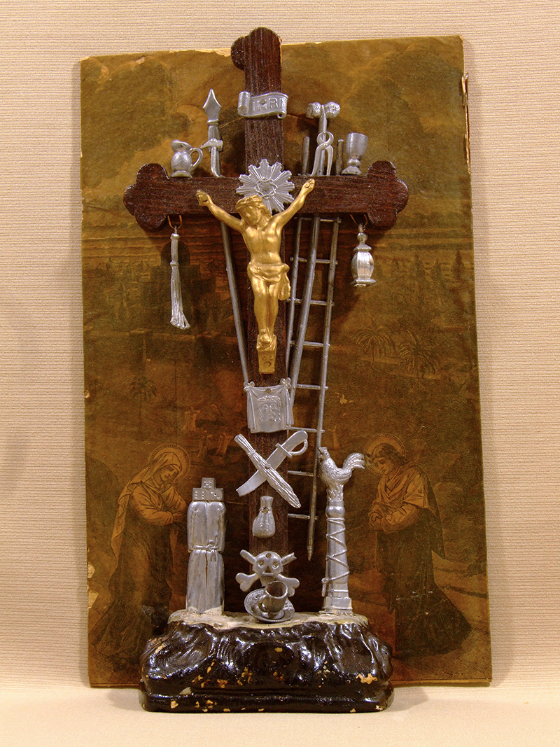 crucifix with a golden Christ and sliver instruments used in his crucifixion surrounding the cross