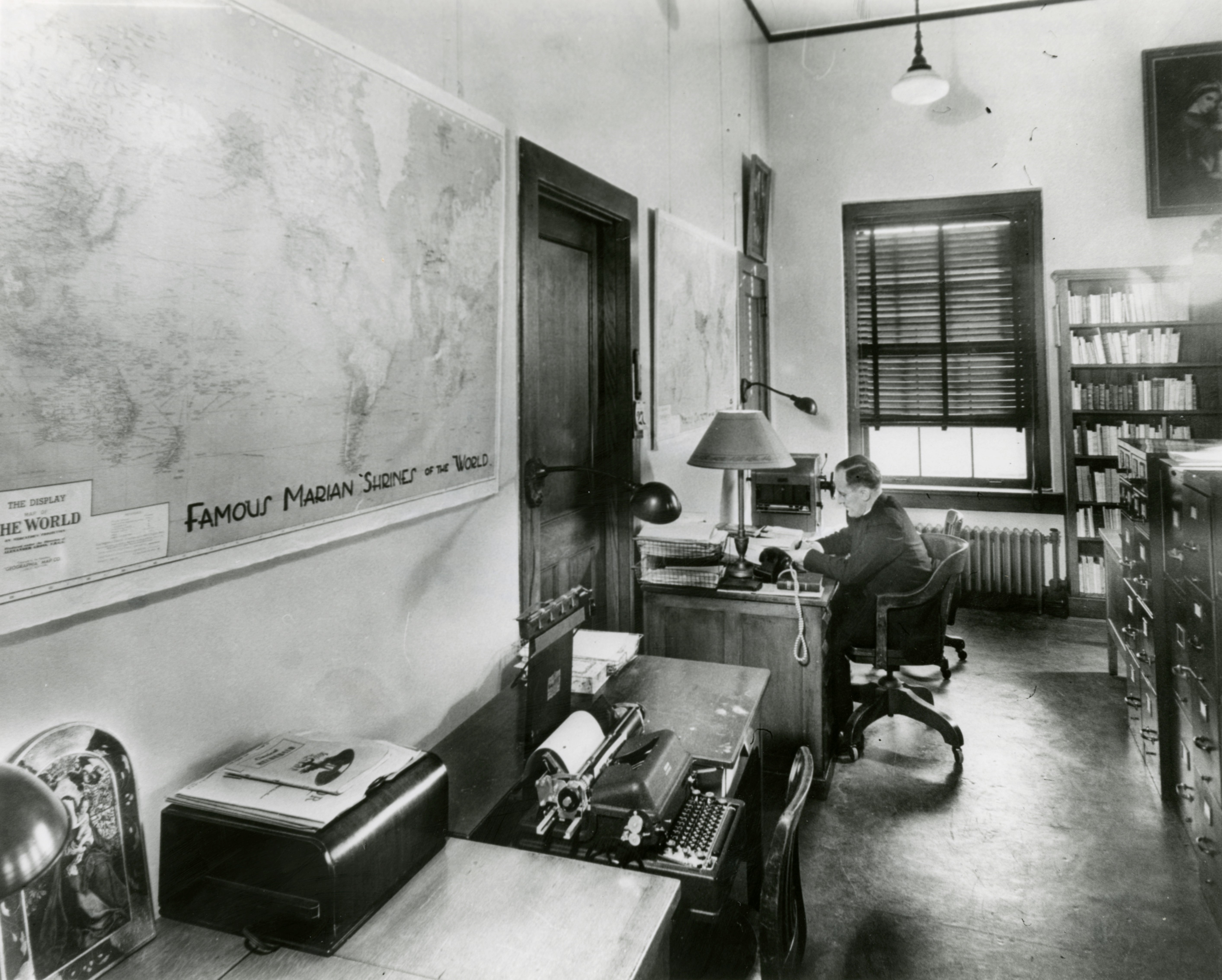 Fr. Lawrence Monheim, director of the Marian Library, in his office, circa 1950. 