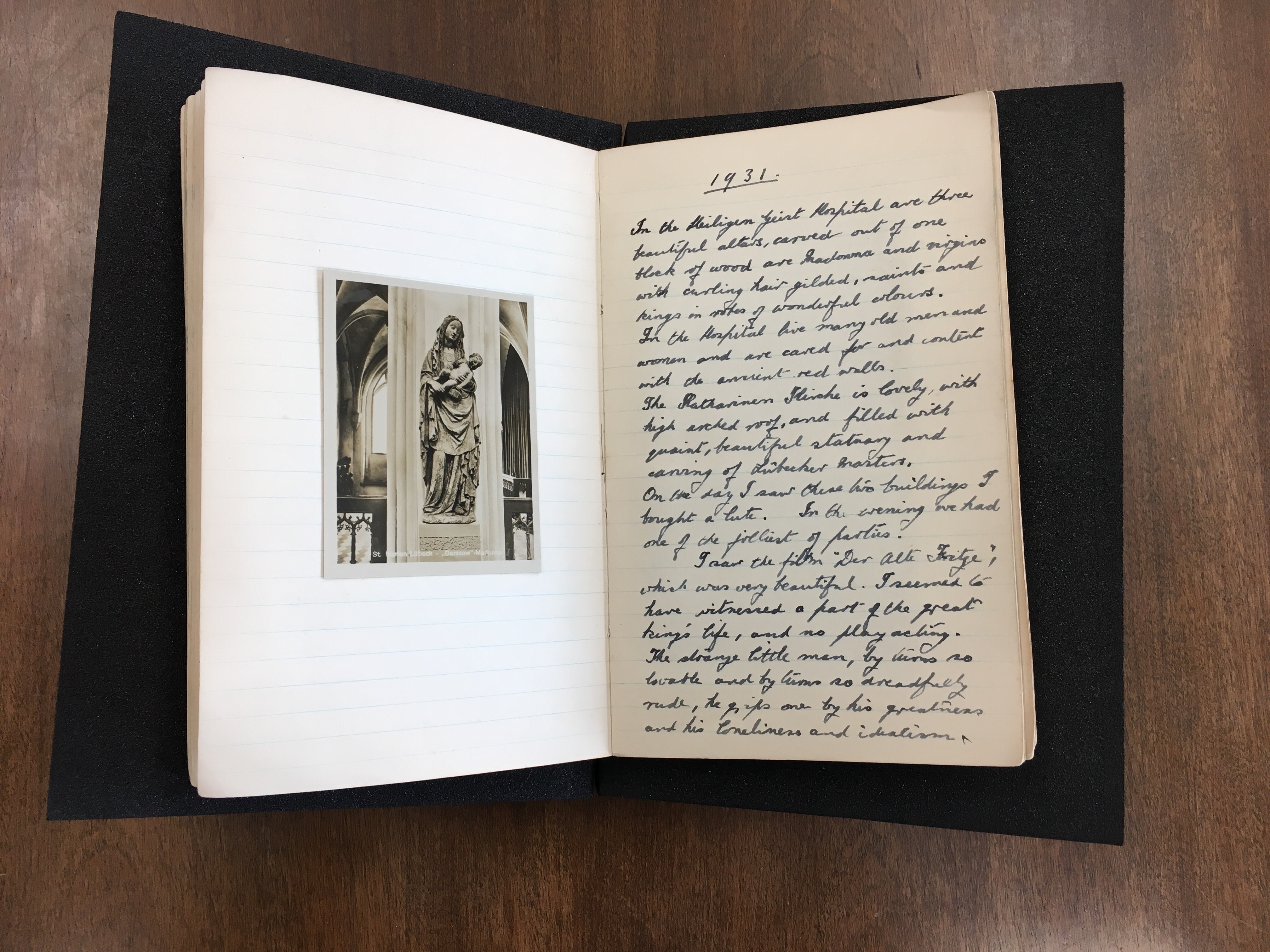 Open diary spread with hand-written entry on the right page and black and white postcard of the Darssow Madonna on the left