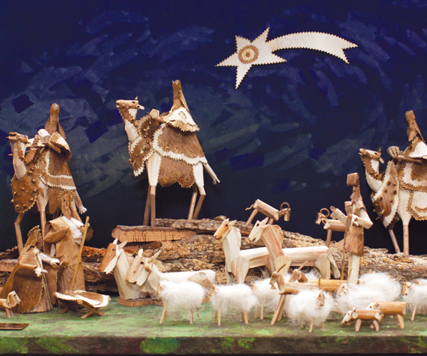 Nativity set made of leaves, twigs, bark and giant fennel. The set features the Magi riding camels on their way to visit the Holy Family. The Holy Family is in the foreground surrounded by livestock including lambs, sheep, cows and donkeys. The Star of Bethlehem is above them, mounted on a blue background made to look like the night sky.