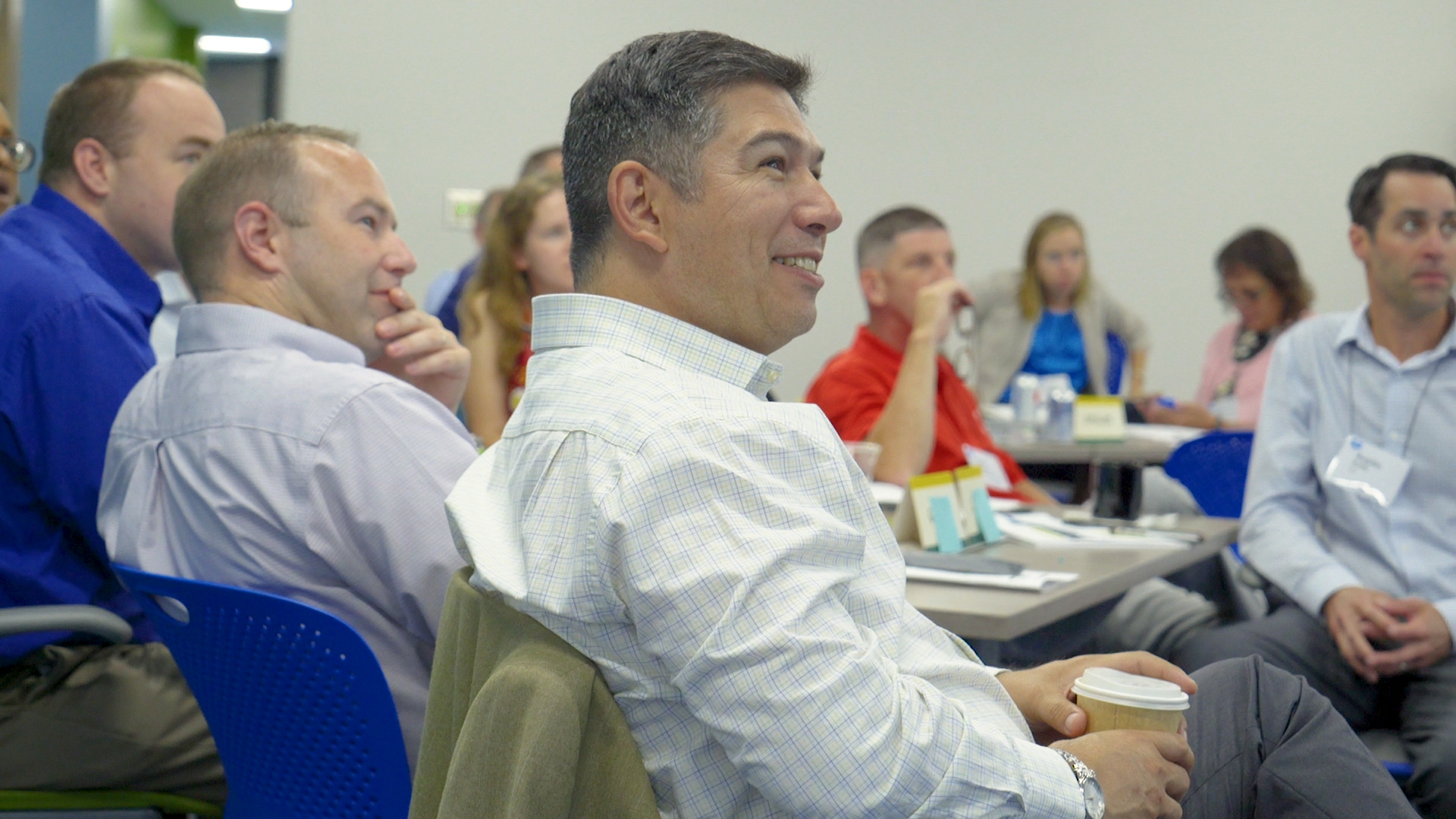 ${ Man in professional development course smiles, looking off to the side }