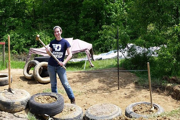 Schalle pounds dirt in tires for foundation of tiny house.