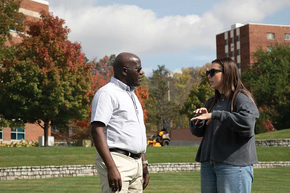 Brother Paul Kagece Ndungu '11 chats with a student on campus.