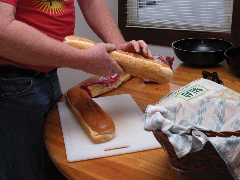 Hands showed slicing a loaf of bread.
