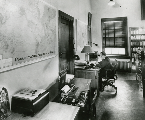 Father Lawrence Monheim, S.M. working at a desk in the library