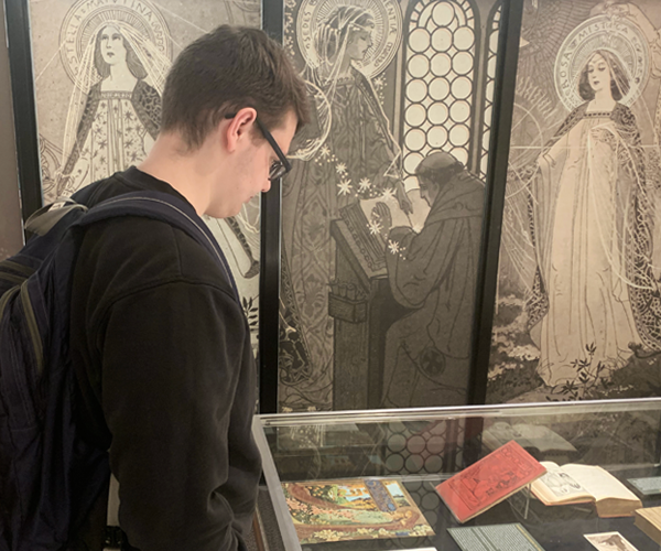 student looking at an exhibit case in the gallery