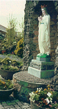 statue of Mary in a garden space surrounded by stone