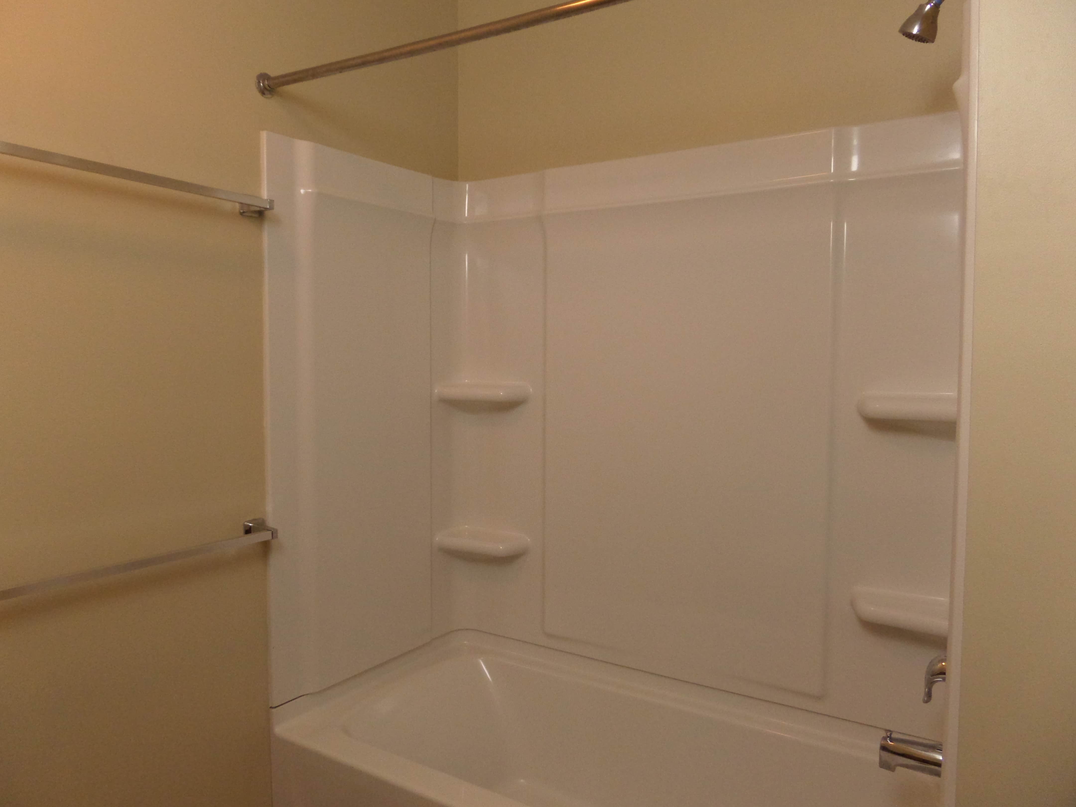 Shared bathroom has towel rails and bath shelves