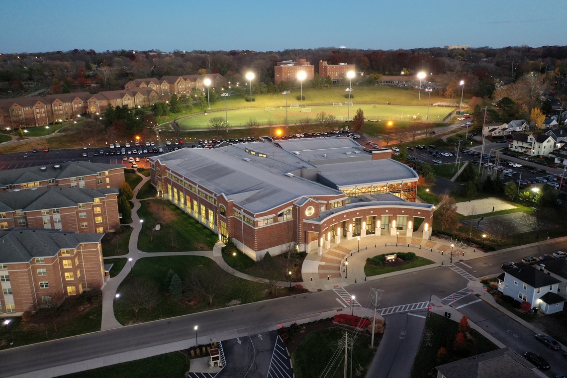 ${ Aerial view photo showing the RecPlex, Stuart Field, and surrounding buildings at night time. }